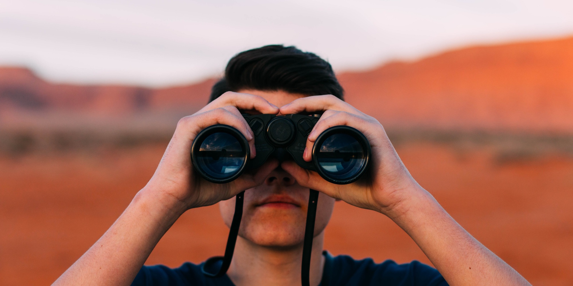 man looking with binoculars